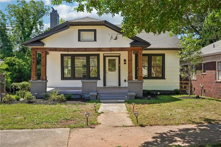 Single-story residence featuring a covered front porch with substantial wood columns and stone bases