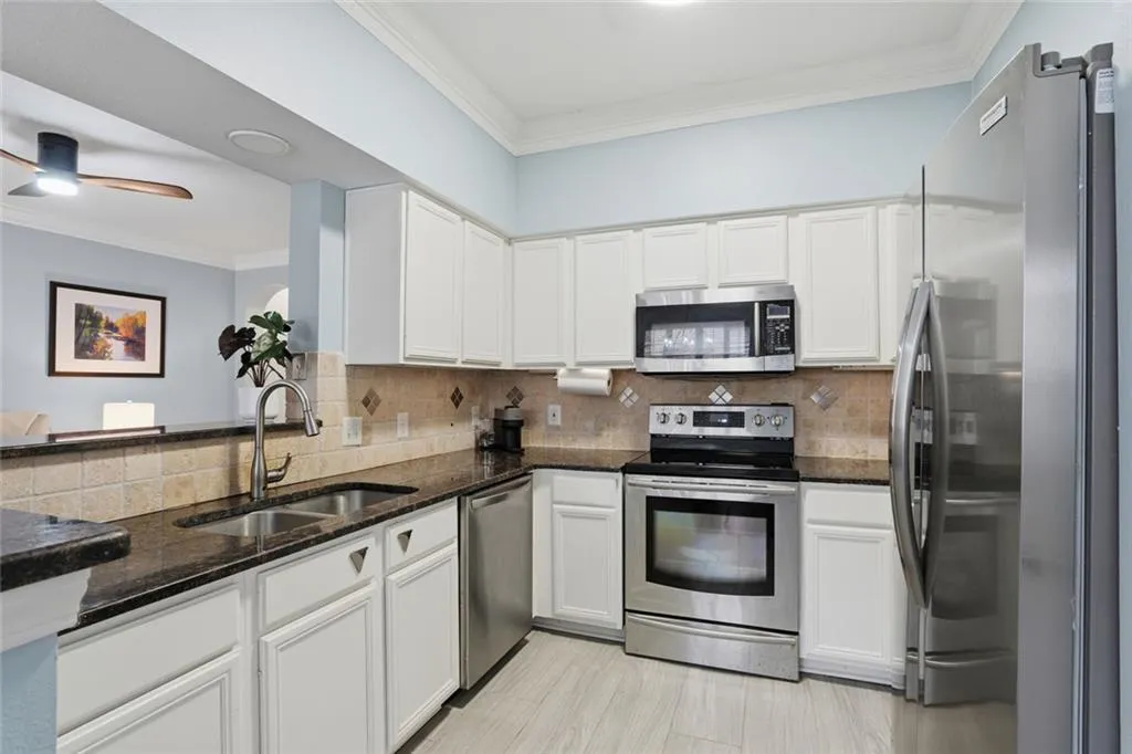 Kitchen has ample Counter Space and Cabinets, S/S Appliances, Granite & Tile Backsplash