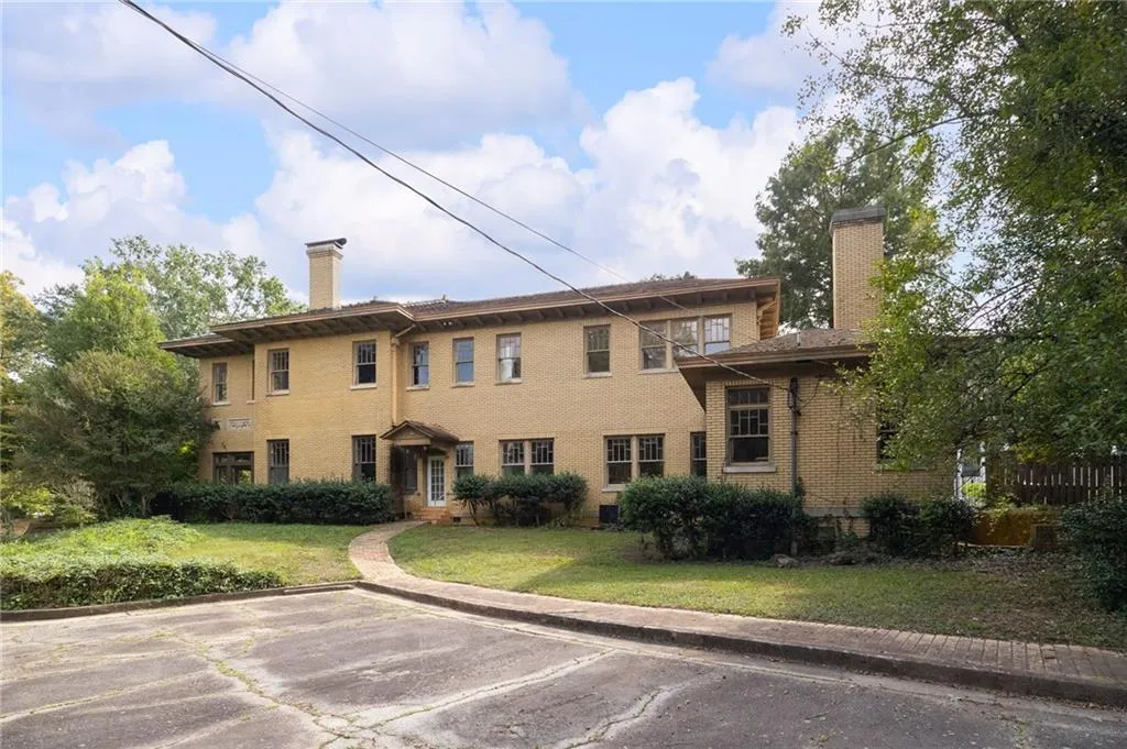 Brick exterior with multiple windows, a covered entry, and a stone walkway
