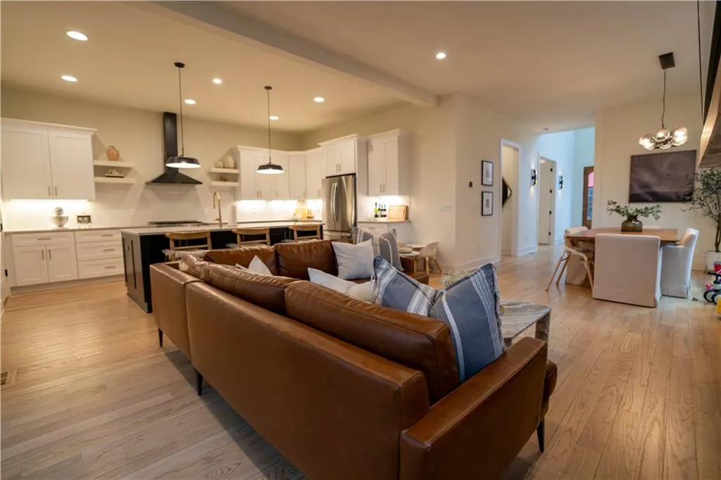 Living room with light wood-style flooring, recessed lighting, and a chandelier