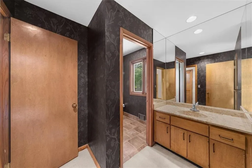 Full bath with vanity, recessed lighting, and baseboards