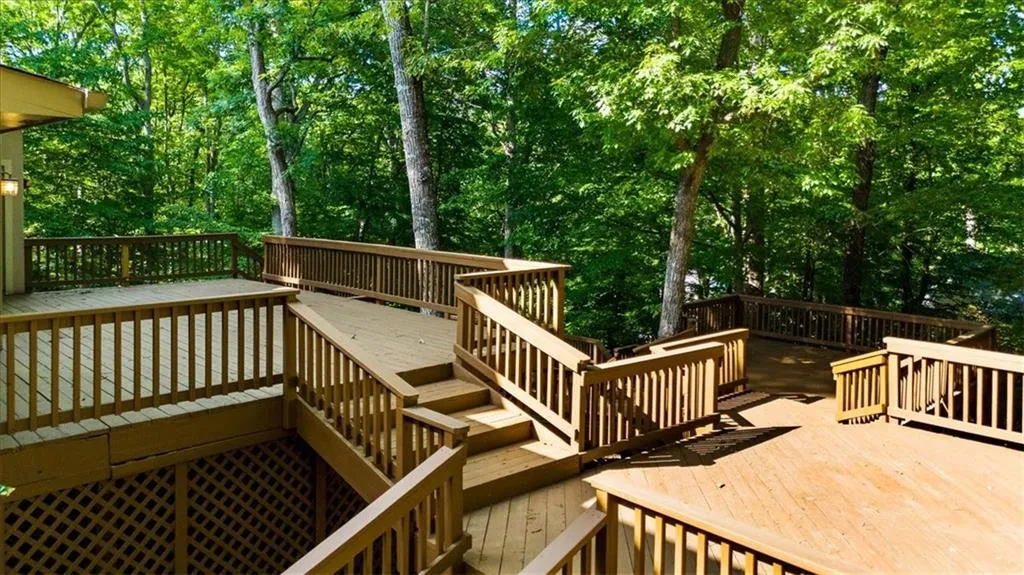 Wooden deck featuring stairway and view of wooded area