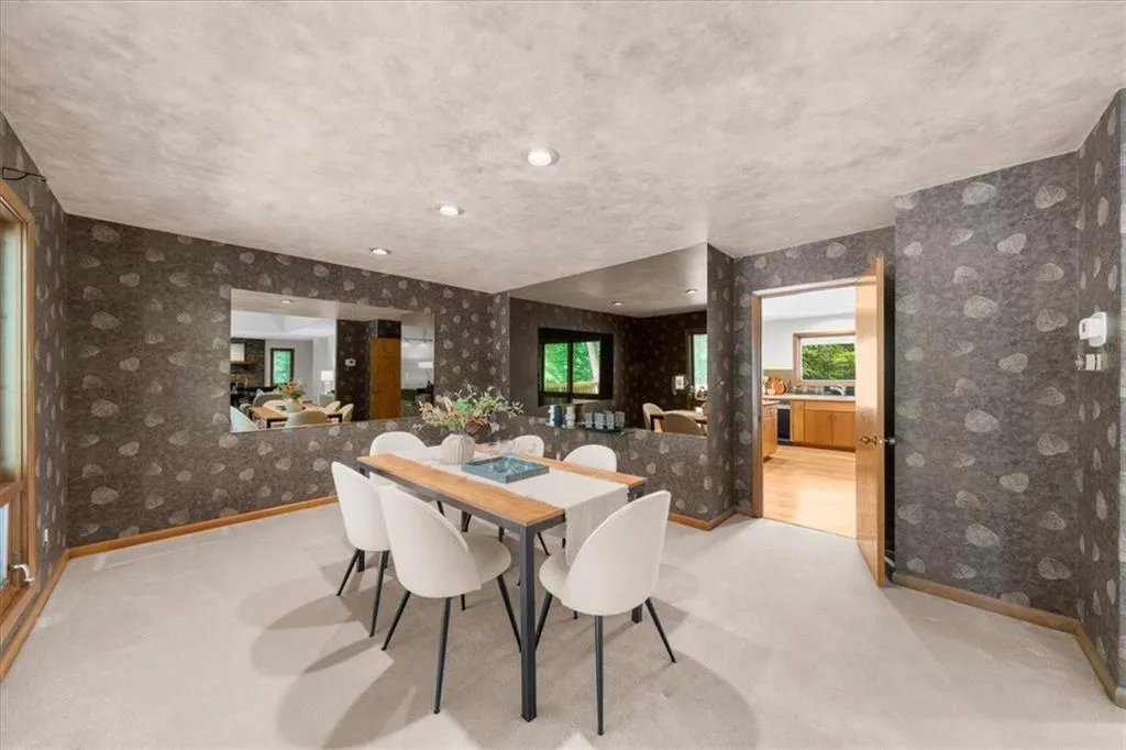 Carpeted dining area featuring wallpapered walls and baseboards