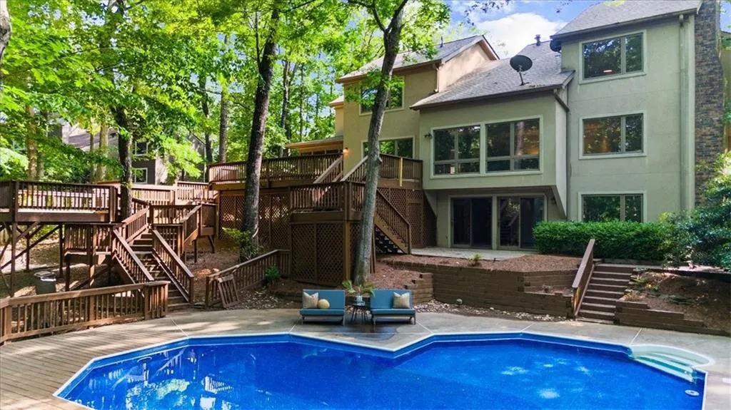 Rear view of property with stairs, a wooden deck, stucco siding, and a patio area