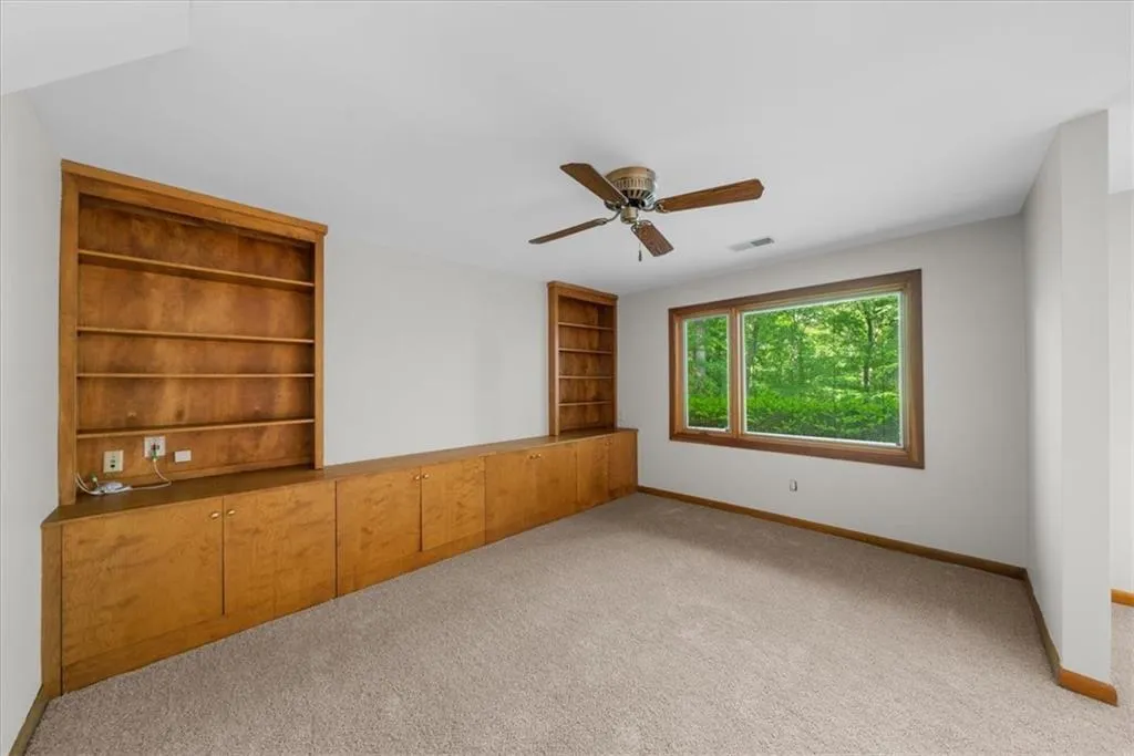 Spare room with baseboards, carpet flooring, and ceiling fan