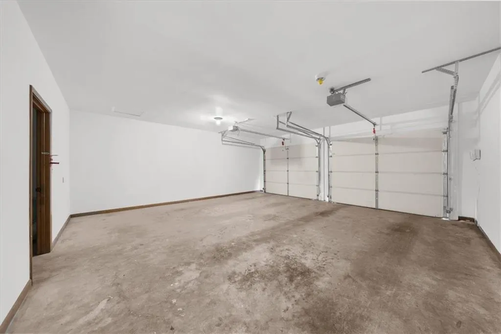 Garage featuring a garage door opener and baseboards