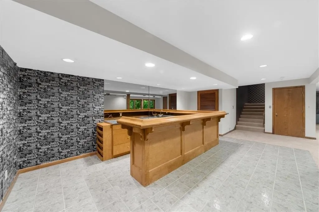 Kitchen featuring a breakfast bar, butcher block countertops, recessed lighting, and a center island