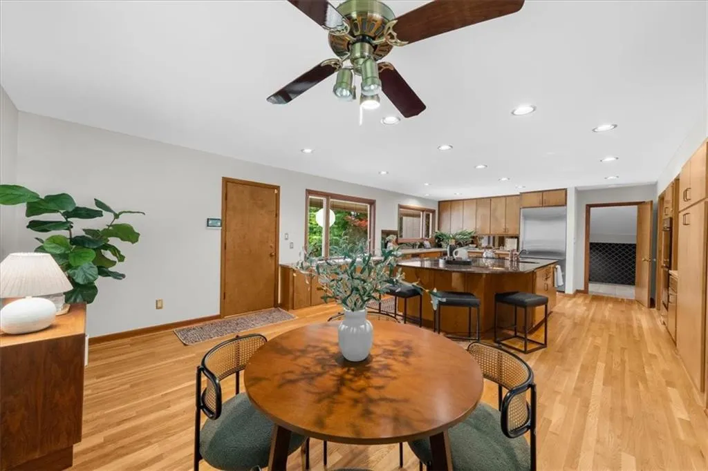 Dining area featuring baseboards, light wood-type flooring, a ceiling fan, and recessed lighting