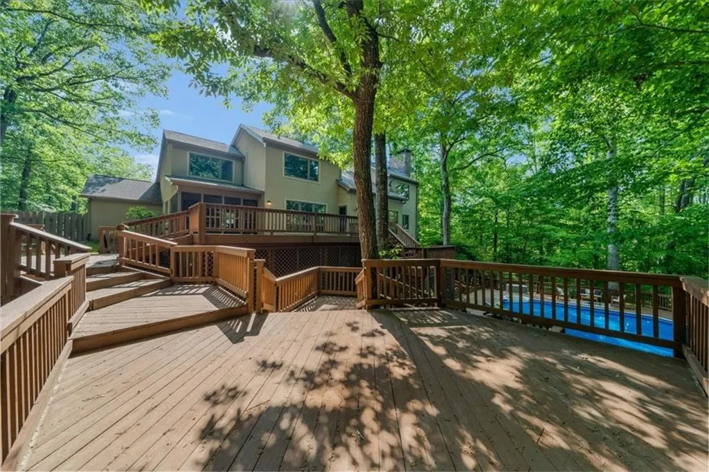 Wooden terrace featuring an outdoor pool and stairs