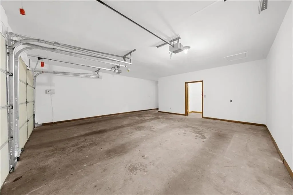 Garage with baseboards and a garage door opener
