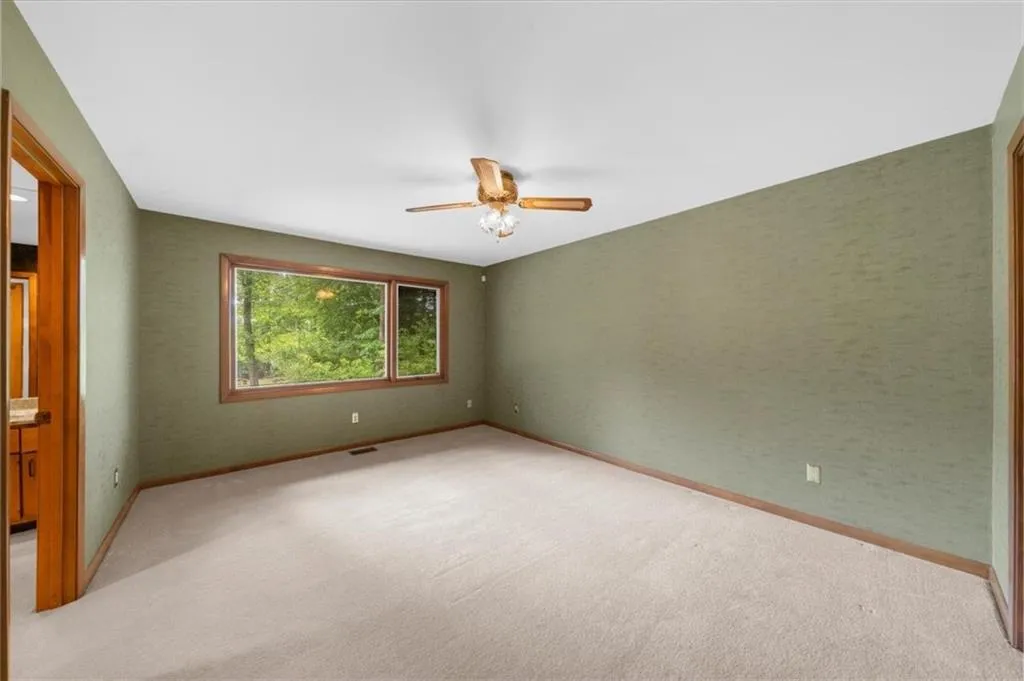Unfurnished room with ceiling fan, light carpet, and baseboards