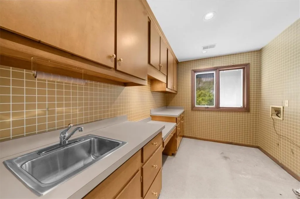 Laundry room featuring cabinet space, light carpet, and washer hookup