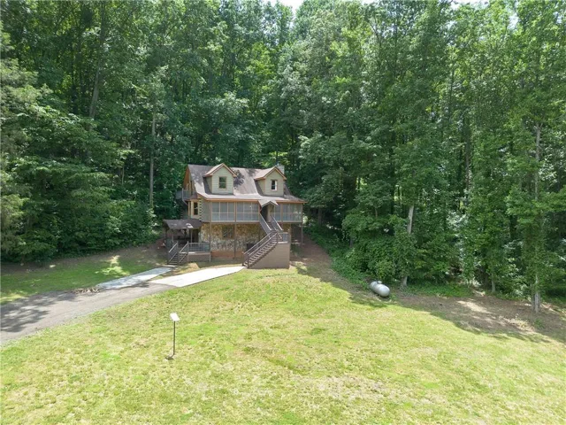 Two-story property featuring a stone and wood siding exterior