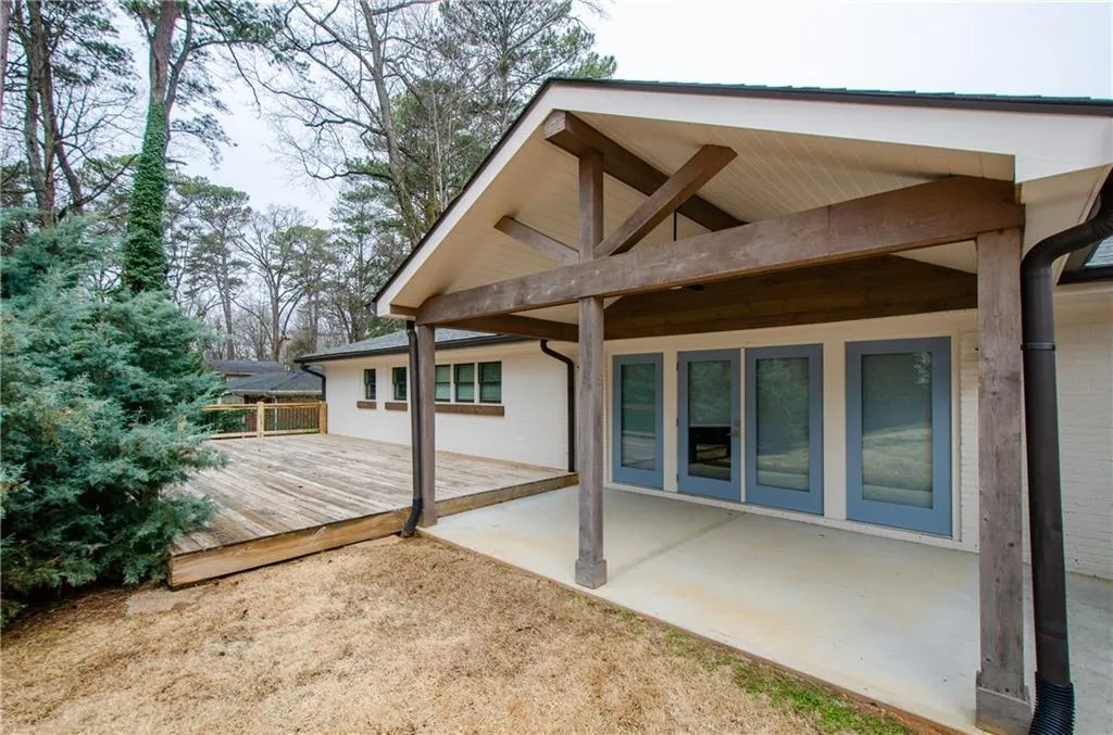 Back of property featuring a deck and a patio