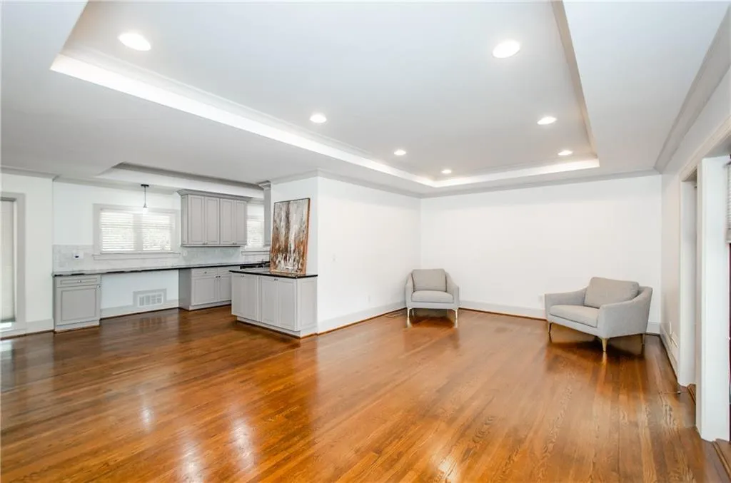 Unfurnished room featuring ornamental molding, dark wood finished floors, a raised ceiling, and recessed lighting