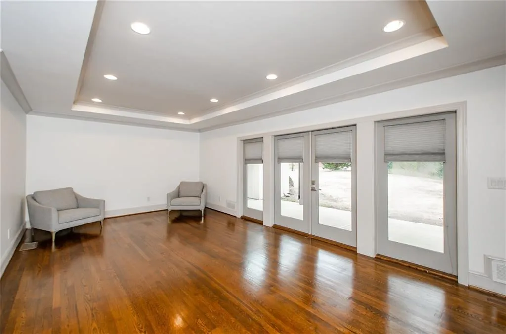 Unfurnished room with a raised ceiling, french doors, crown molding, recessed lighting, and hardwood / wood-style floors
