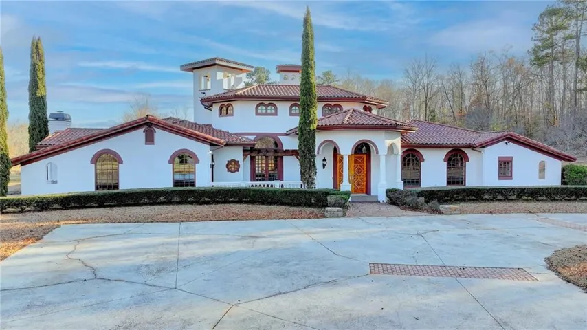 Mediterranean / spanish-style home with stucco siding, a tile roof, and driveway