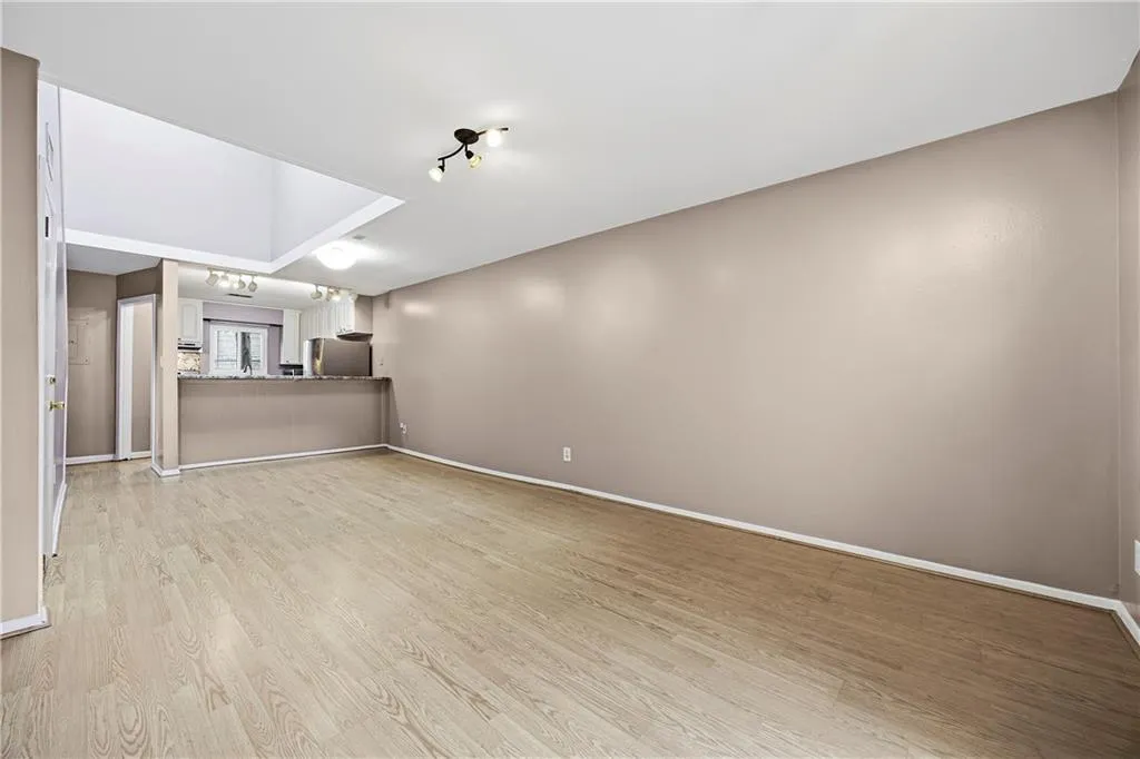 Unfurnished living room featuring light wood-style flooring and baseboards
