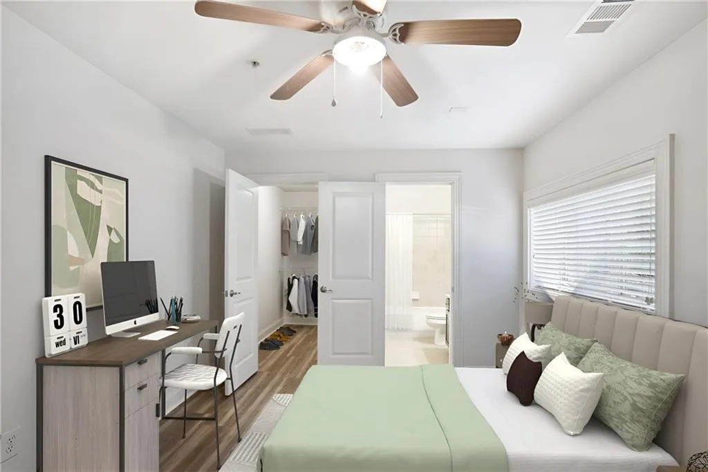 Bedroom featuring ceiling fan, a closet, connected bathroom, and hardwood / wood-style floors