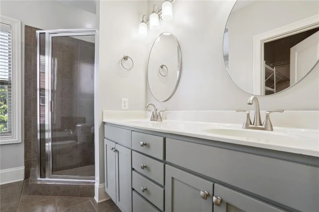 Owner's bathroom with dual vanities, large garden tub and large tiled shower.