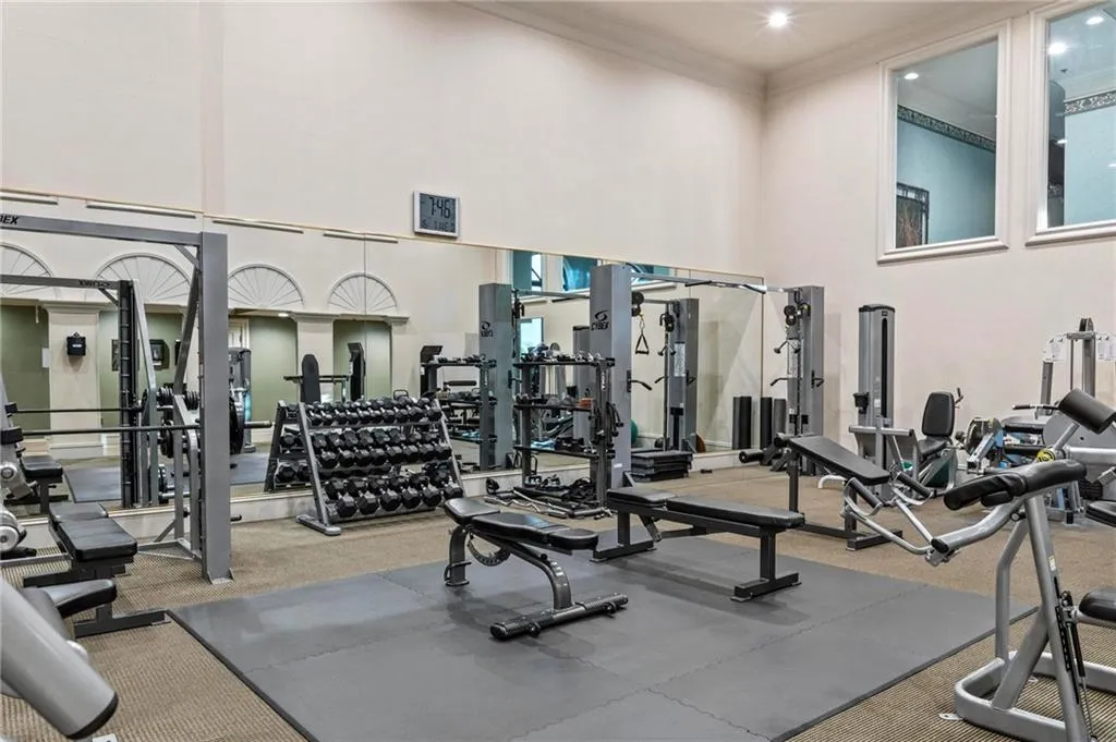 Workout area with a towering ceiling, crown molding, and carpet floors