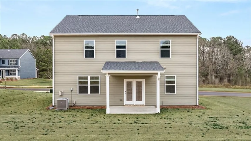 Back of property with a yard, a shingled roof, a patio, and french doors