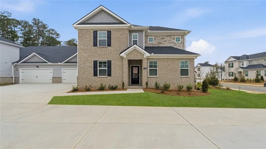 View of front of house with driveway, a garage, a front yard, brick siding, and a shingled roof