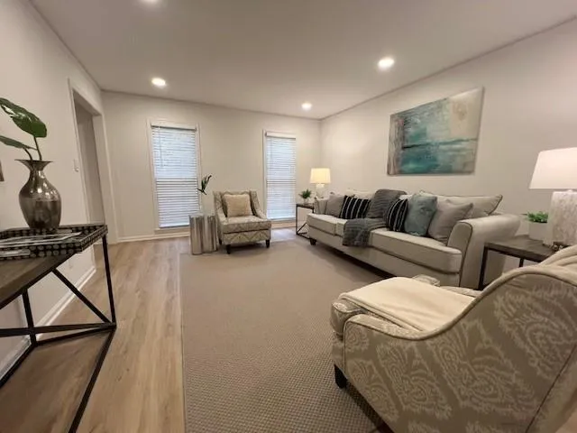 Living area with light wood-style floors and recessed lighting