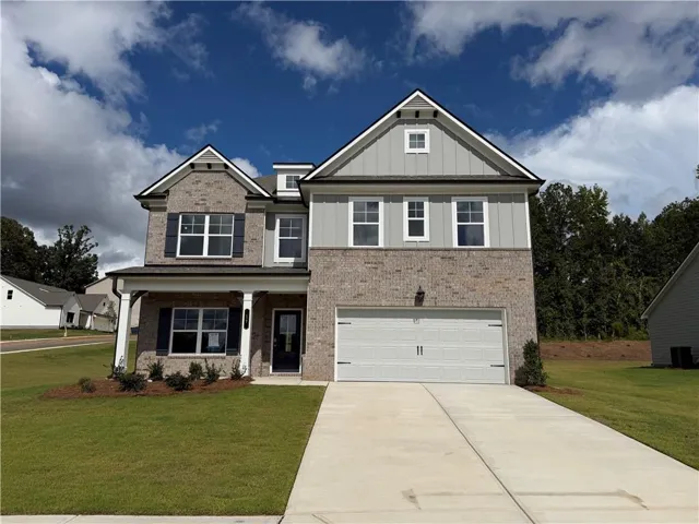 Two-story exterior featuring a brick and siding facade, covered front porch with pillar supports, attached two-car garage, and a concrete driveway