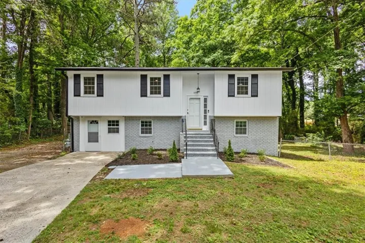 Exterior features white horizontal siding and painted brick