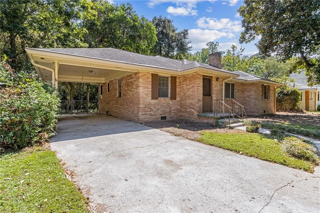 Ranch-style home with brick siding, concrete driveway, a chimney, crawl space, and an attached carport