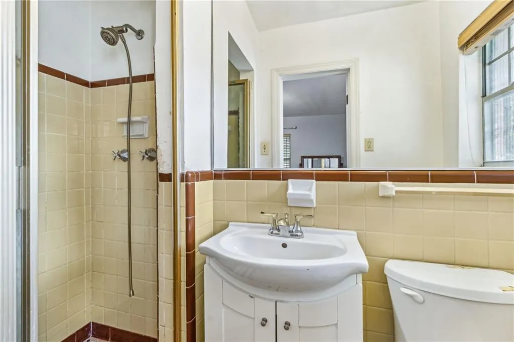 Bathroom featuring vanity, a stall shower, and tile walls