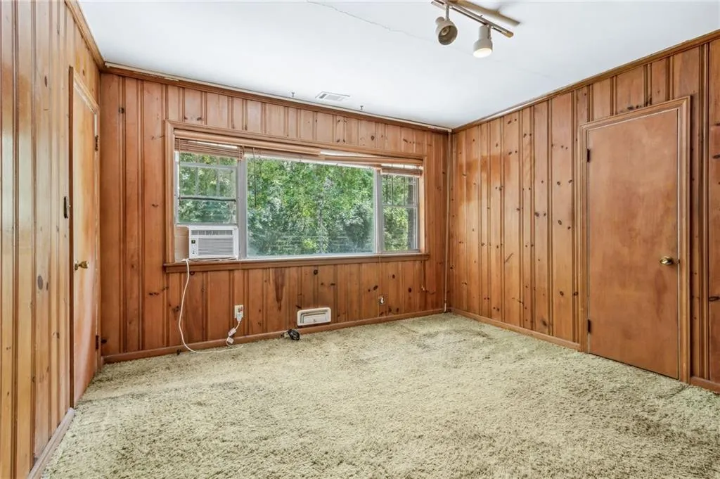 Flexible Space for 3rd Bedroom/Home Office or Family Den carpeted empty room featuring baseboards and wood walls