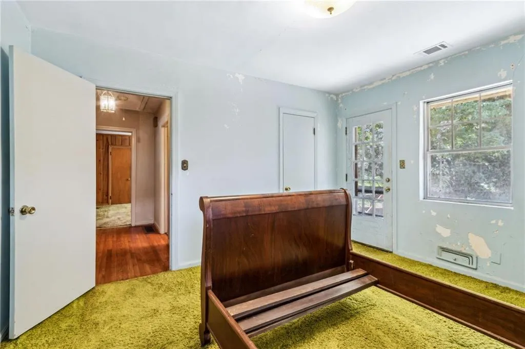 Carpeted bedroom with attic access and access to outside