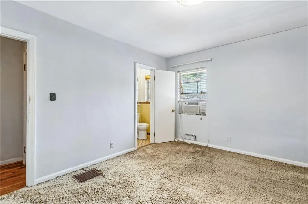 Primary Bedroom featuring ensuite bathroom and carpet