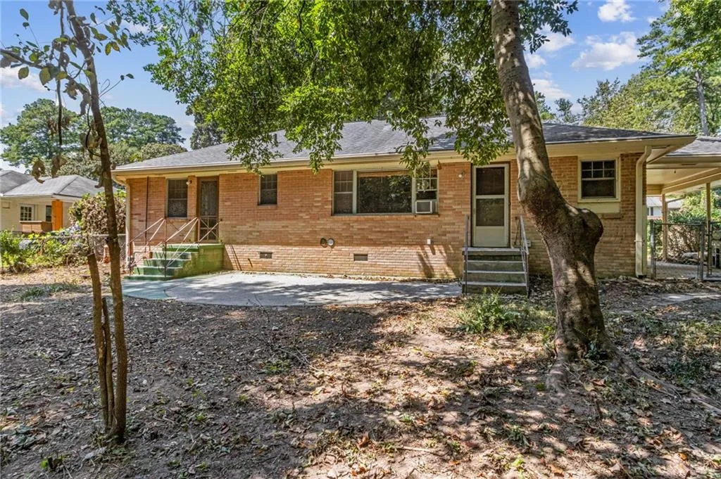 View of back of home facade featuring crawl space, a patio area, brick siding, and 2 rear entry steps