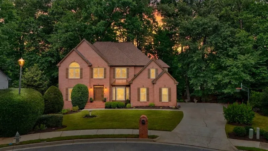The stunning twilight view beautifully showcases the home's elegant exterior, warm ambiance, and exceptional curb appeal.