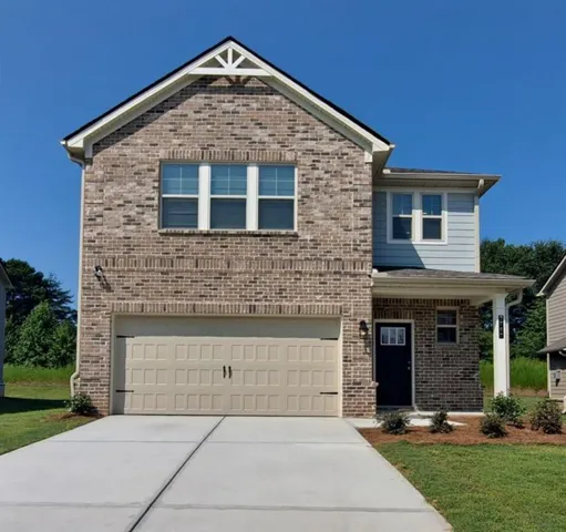 Brick and siding exterior with a covered entry, attached garage, and concrete driveway