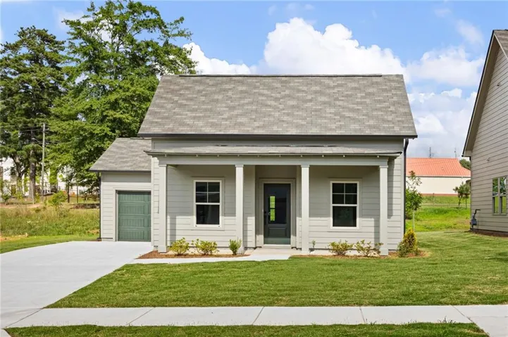 Light gray siding exterior with a covered porch entry, a single-car garage, gray shingle roofing, and a manicured front lawn