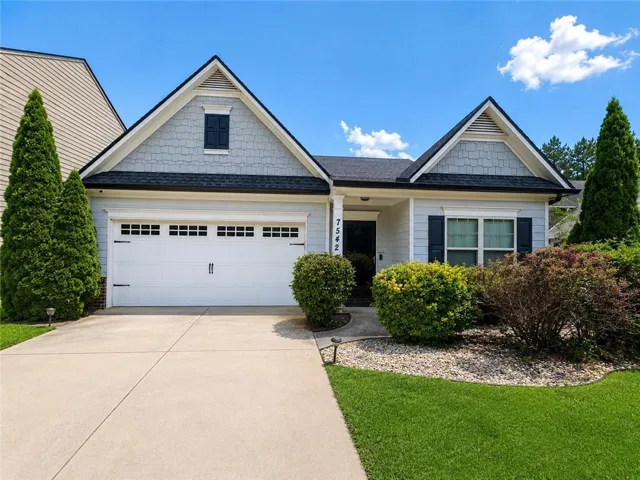Front exterior featuring light gray siding, dark gray shingle roofing, and a two-car garage