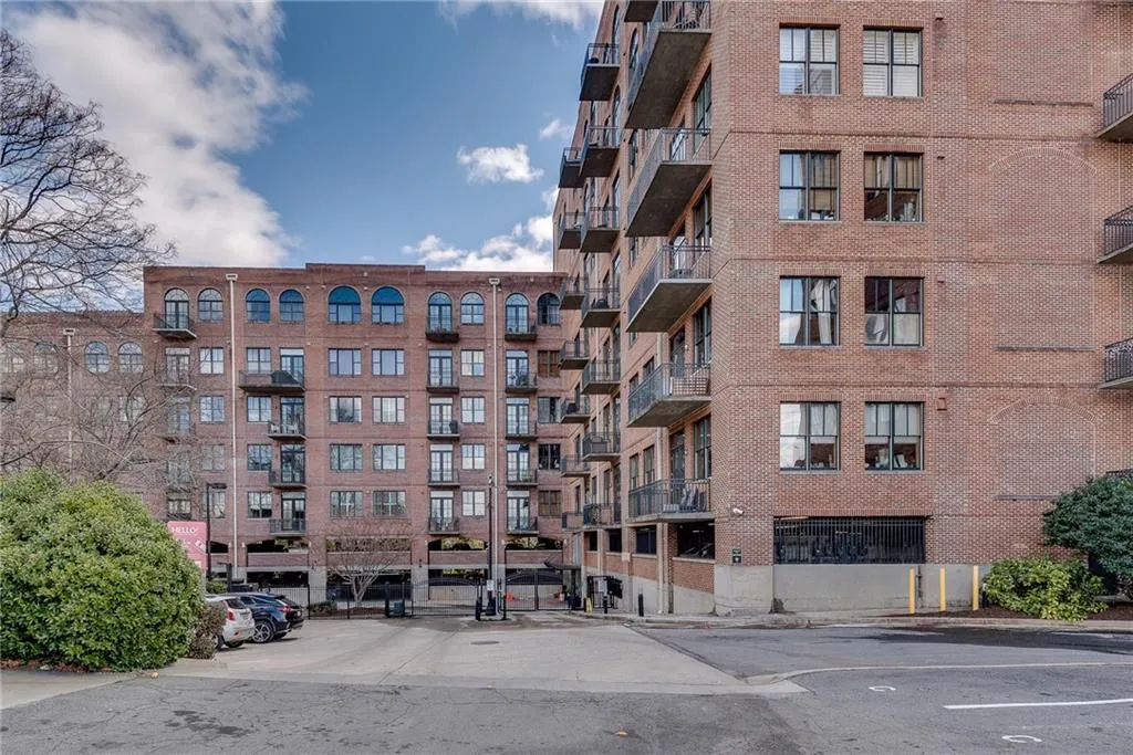 View of apartment building / complex featuring uncovered parking