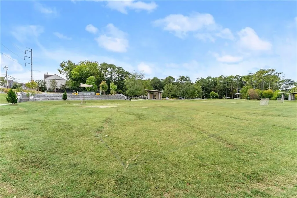 View of green lawn featuring view of scattered trees