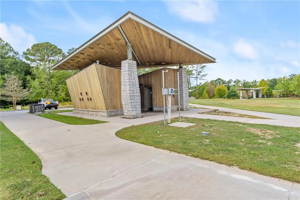 View of property's community with a yard, mail area, and view of scattered trees