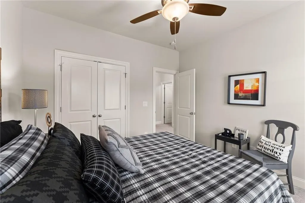 Bedroom featuring a closet, ceiling fan, and light carpet