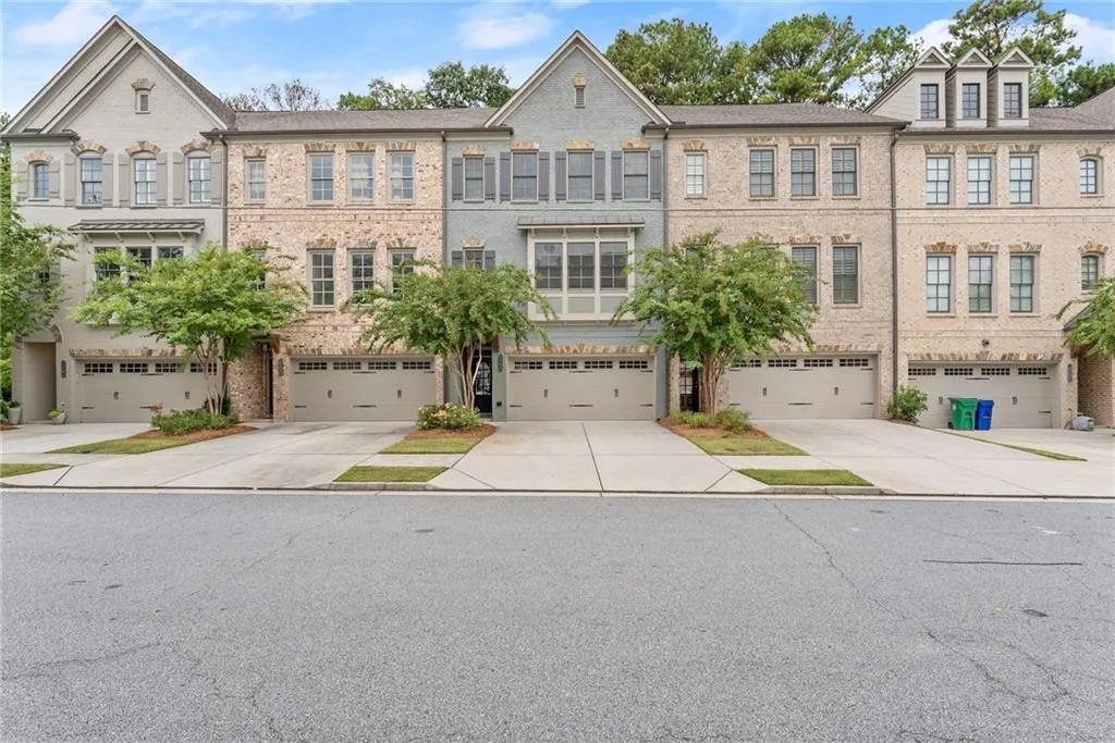 View of front of property featuring brick siding, driveway, and an attached garage