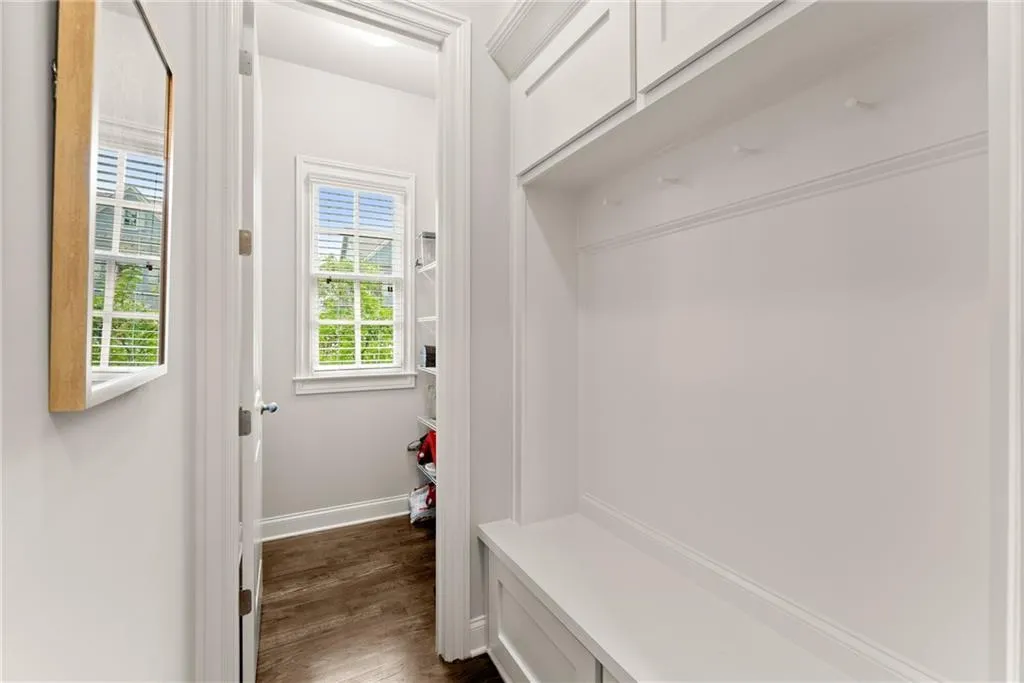 Mudroom featuring dark wood-style floors and baseboards