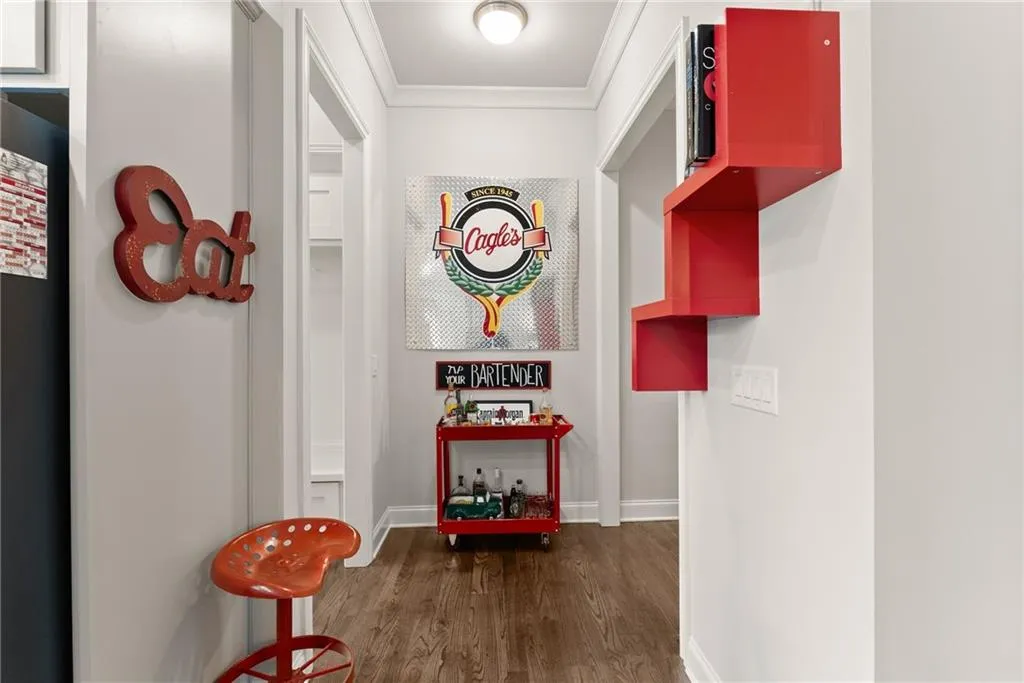 Corridor featuring ornamental molding and dark wood-style floors