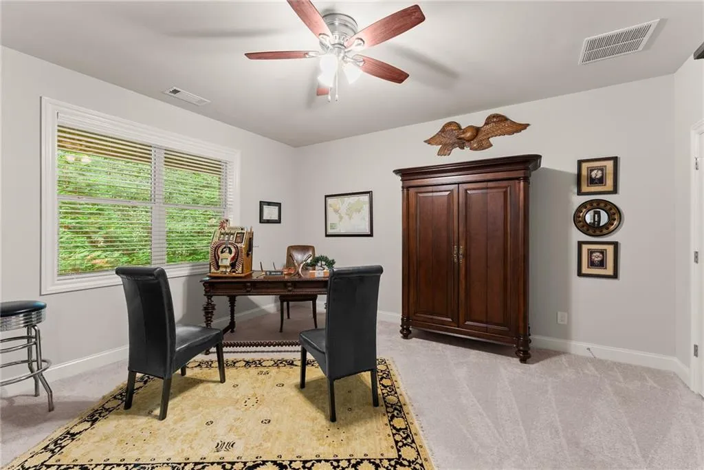 Home office featuring light colored carpet and ceiling fan