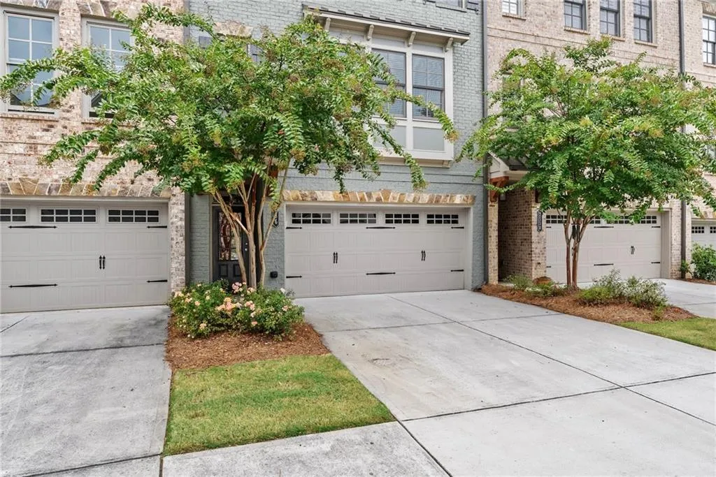 View of front of house with concrete driveway, brick siding, and an attached garage