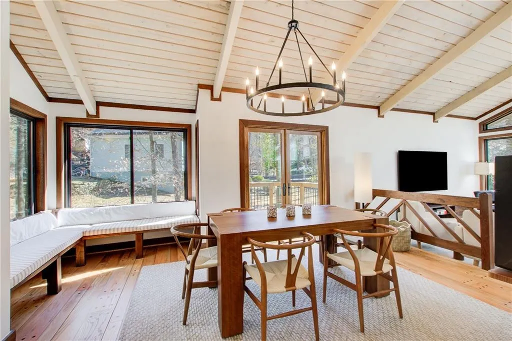 Banquet size dining room with lofted ceiling with beams, wooden ceiling and hard wood flooring. Lots of light in this house.